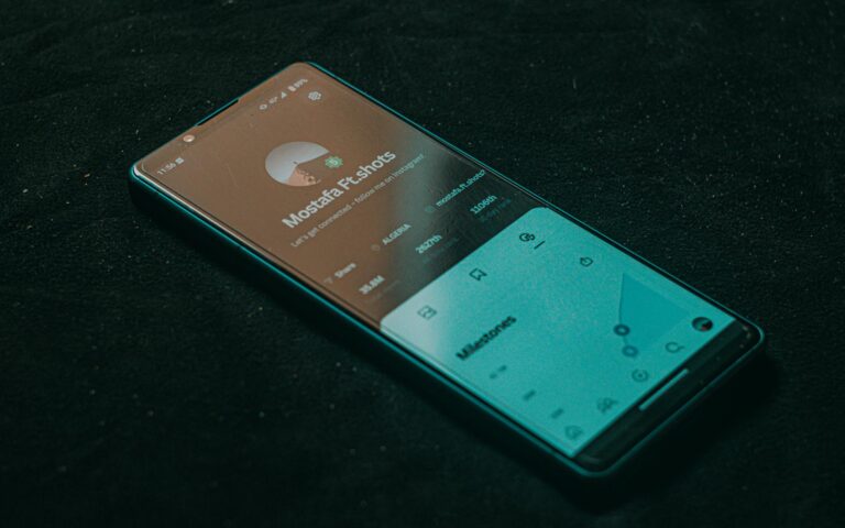 A smartphone displaying an app screen lies on a dark surface, highlighting technology.