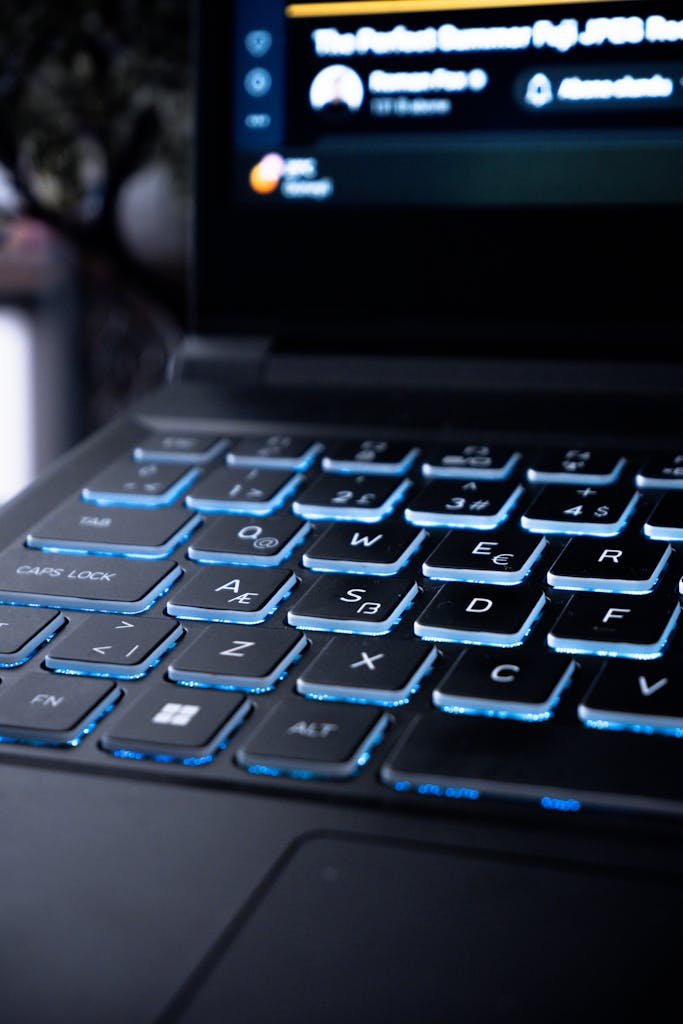 Close-up of a modern gaming laptop keyboard with blue backlit keys, suitable for tech and lifestyle themes.