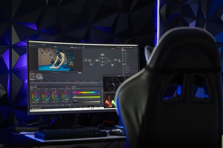 Curved monitor displaying video editing software in a tech-savvy workspace with mood lighting.